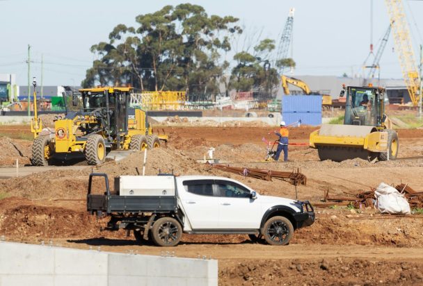 White work ute driving through an Australian industrial site