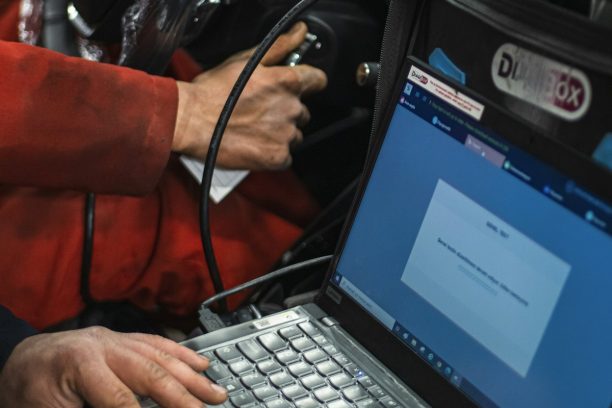 Auto locksmith programming a car key with a laptop